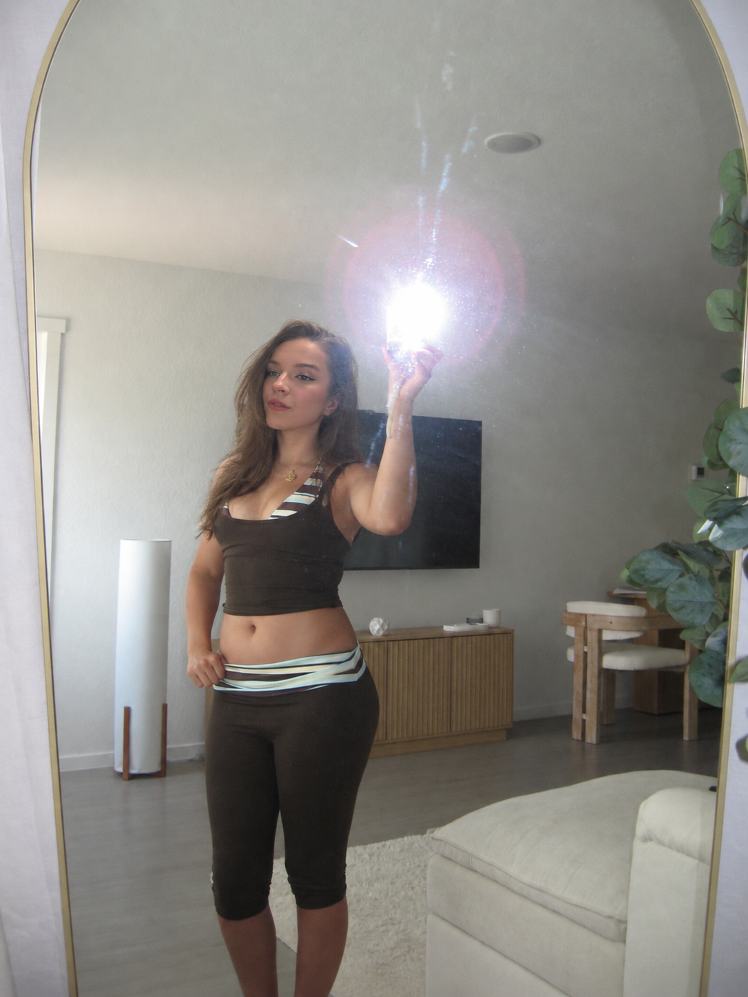 Lucy taking a mirror photo in a matching brown outfit